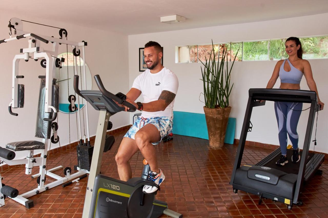 Hotel Boutique Frangipani Brotas Exterior photo A man and a woman exercise on a treadmill and a stationary bicycle.
