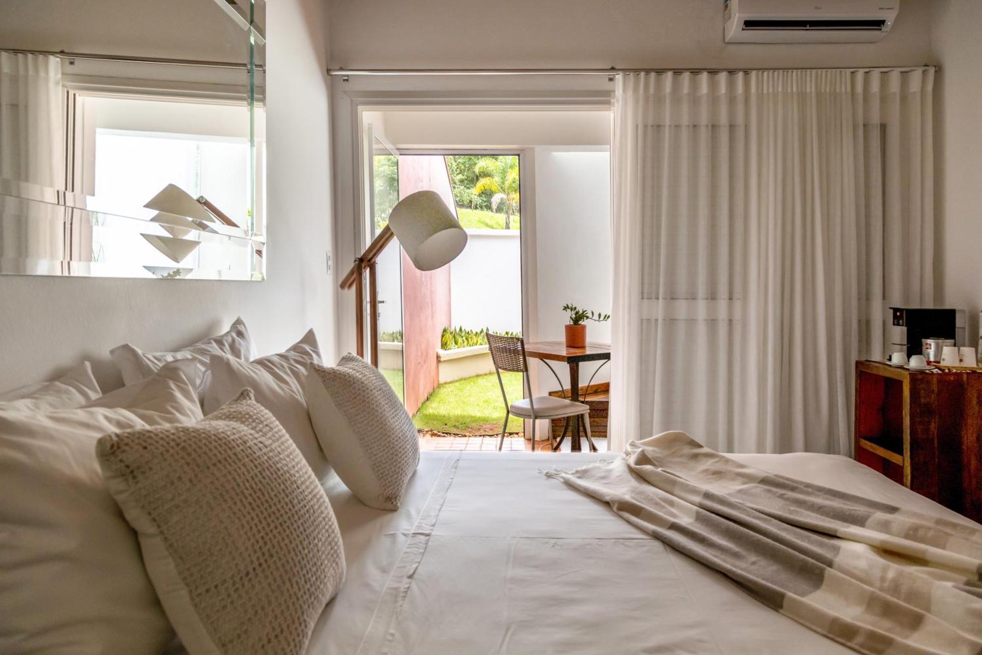 Hotel Boutique Frangipani Brotas Exterior photo A bedroom with a floor-standing lamp